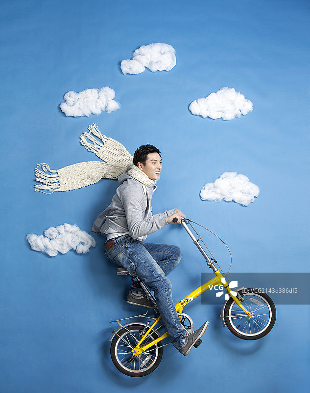 青年男子模仿在空中骑自行车图片素材