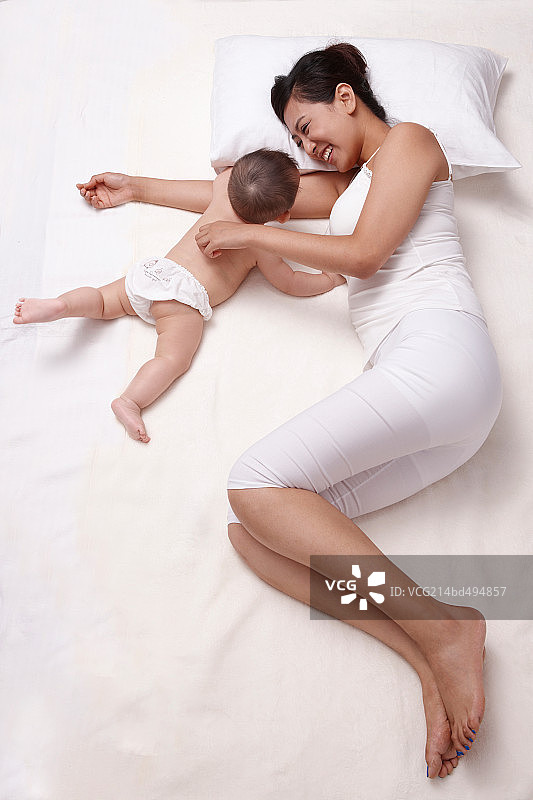 母亲和婴儿躺在床上休息图片素材