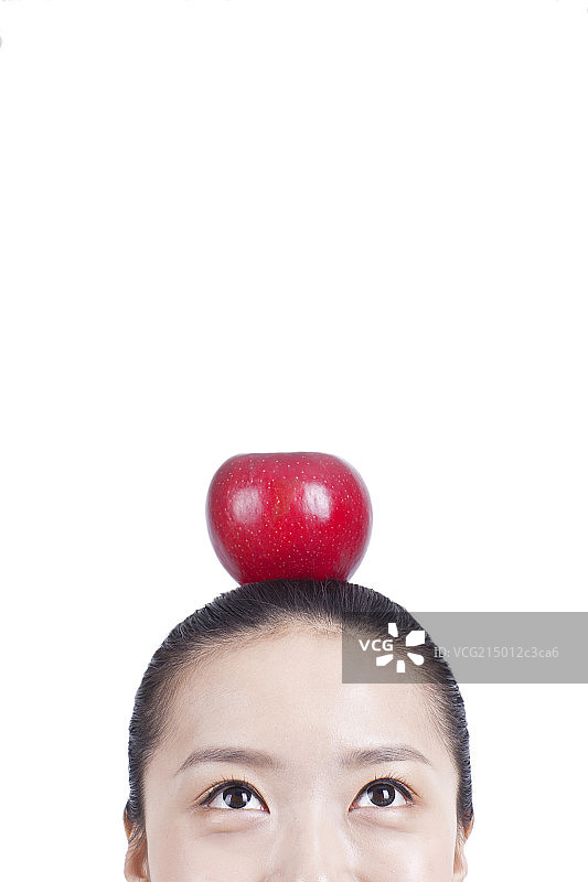 休闲女士头顶着一颗苹果图片素材