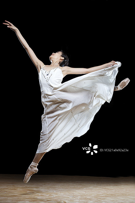黑背景中的白衣芭蕾舞者图片素材