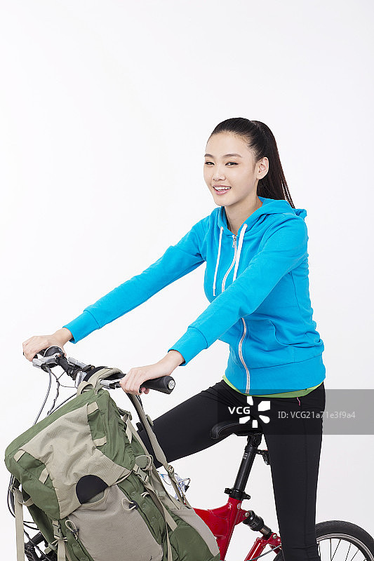 青年女性背着背包骑自行车图片素材