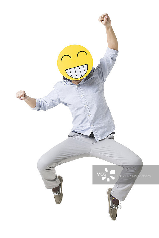 年轻男子戴着卡通笑脸跳跃图片素材