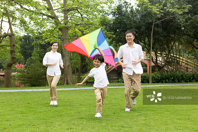 快乐的一家人在公园放风筝图片素材