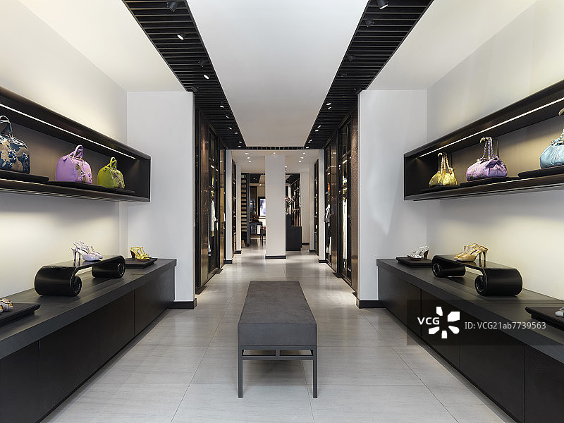 Interior of clothes store with shoes and purses on display图片素材