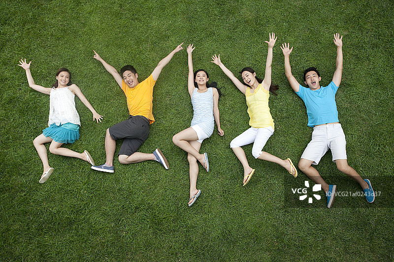 年轻男女在草地上模仿跳跃图片素材