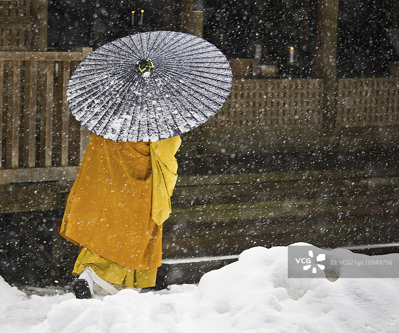 在高野山，一位佛教僧人在风雪中行走，高野山是真传佛教的中心。图片素材