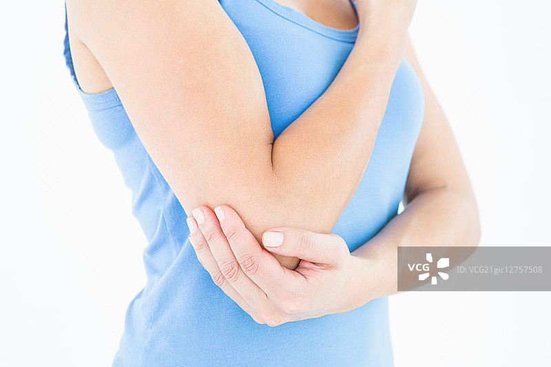 女人在白色的背景上触摸着疼痛的手肘图片素材
