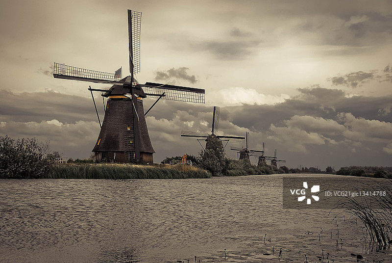 荷兰南部肯德代克阴天下河边的风车图片素材
