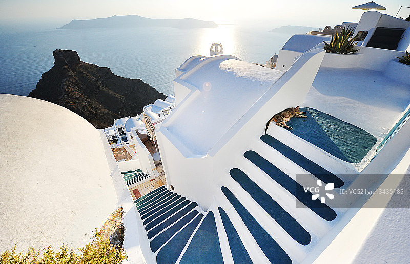 希腊圣托里尼岛，一只猫懒洋洋地躺在楼梯上。图片素材