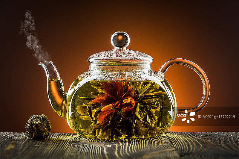 木桌玻璃茶壶，茶花盛开图片素材