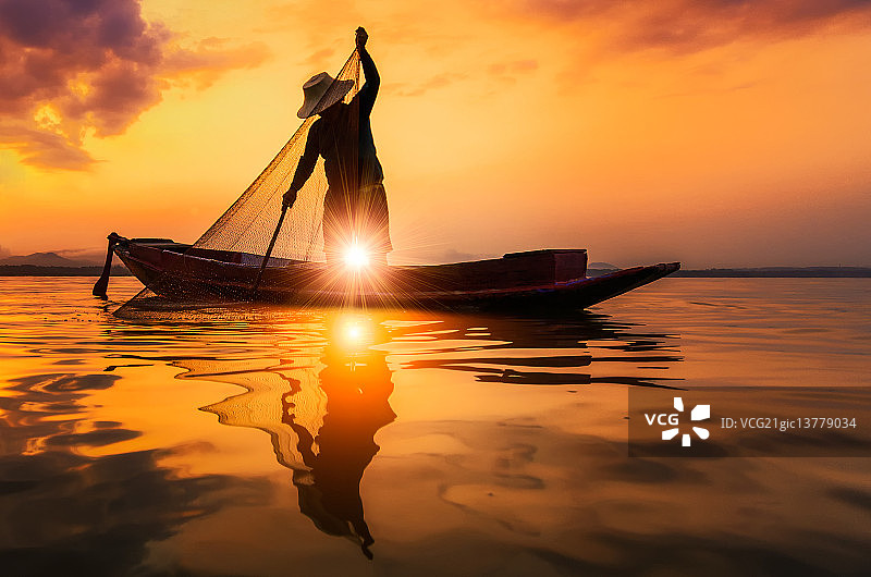 泰国班普拉湖日落时渔夫的剪影。图片素材
