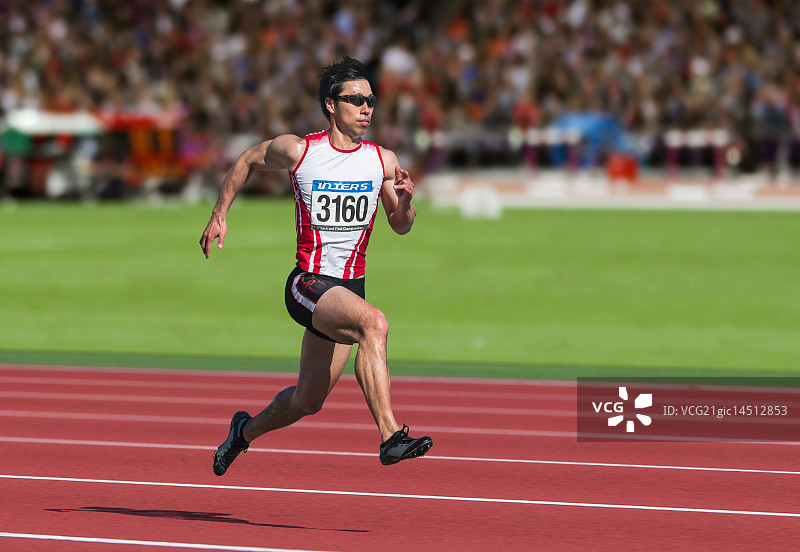 在跑道上奔跑的日本男子短跑运动员图片素材