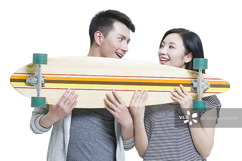 快乐的年轻情侣拿着一个滑板图片素材
