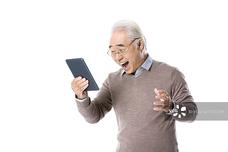 一位老年人在使用平板电脑图片素材