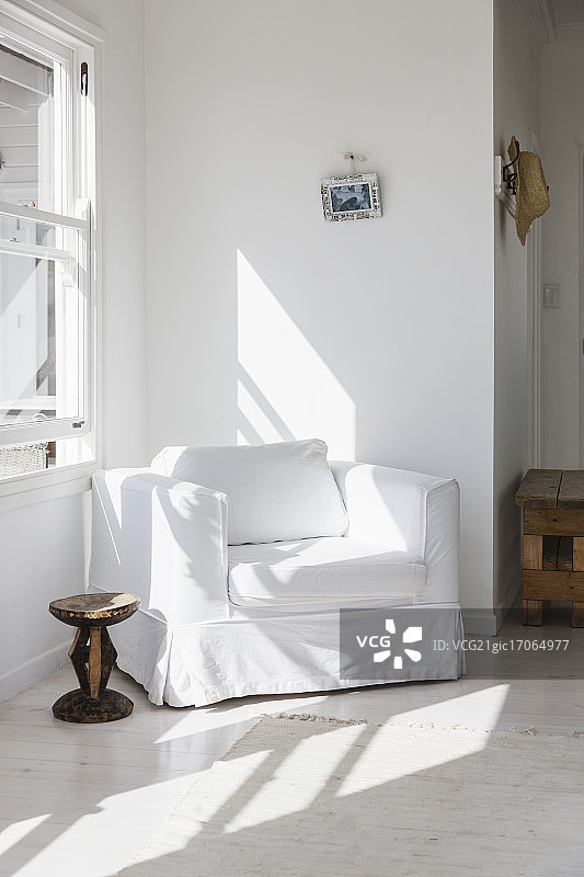 阳光照在角落里的白色扶手椅上图片素材