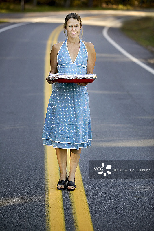 在路上拿着烤盘的女人图片素材