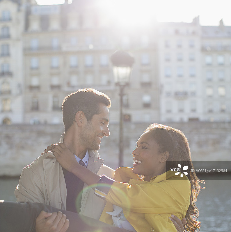 法国巴黎，一名男子在塞纳河边抱着女友图片素材