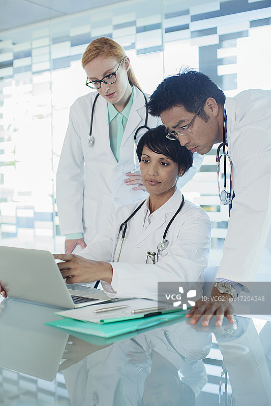 医生使用笔记本电脑讨论病人的治疗图片素材