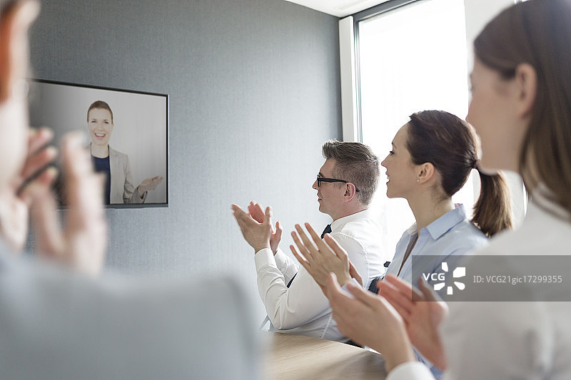 商界人士在视频会议屏幕上为商界女性鼓掌图片素材