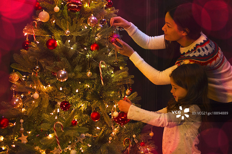 母亲和女儿装饰圣诞树图片素材