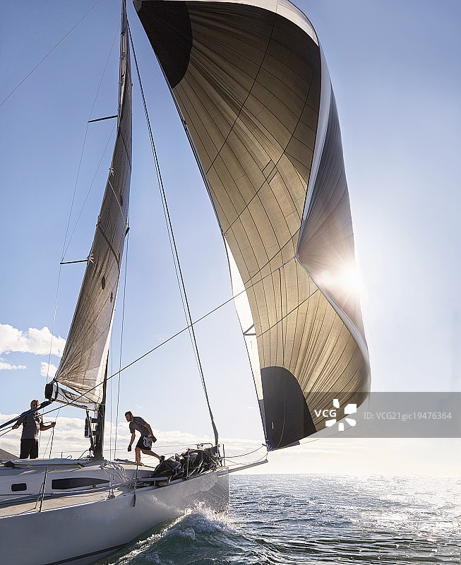 风儿拉着帆船的帆在阳光明媚的海洋上图片素材