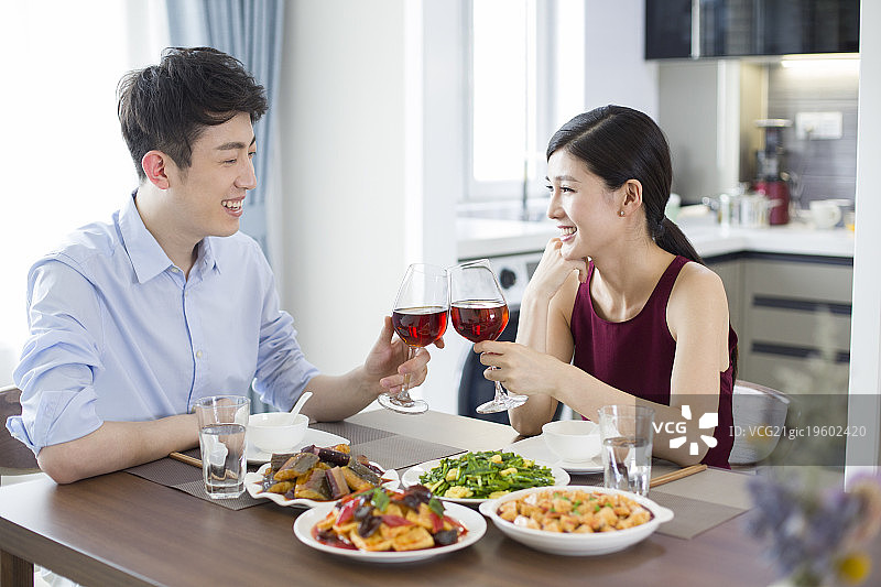 年轻夫妇在家喝红酒吃午餐图片素材