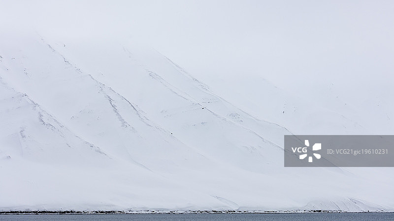 斯匹次卑尔根岛，斯瓦尔巴群岛，白色的雪山和北冰洋在前景图片素材