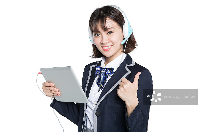 young student using digital tablet with headset图片素材