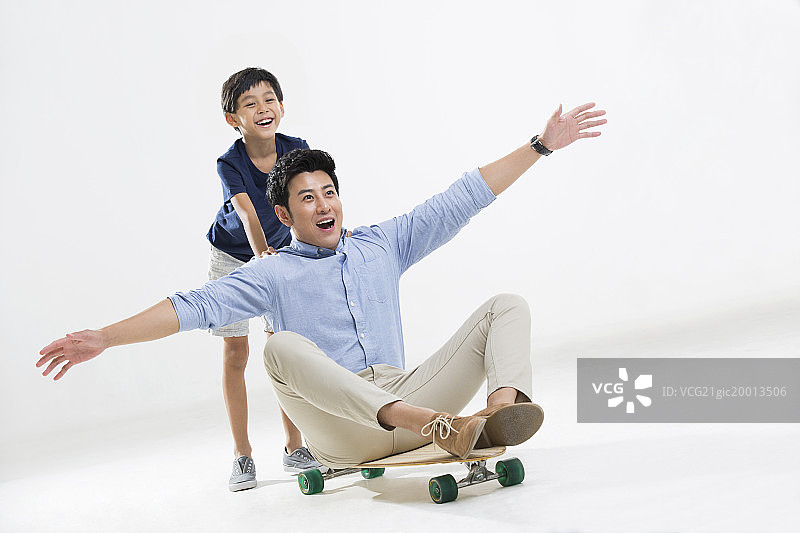 可爱的小男孩和爸爸玩滑板图片素材