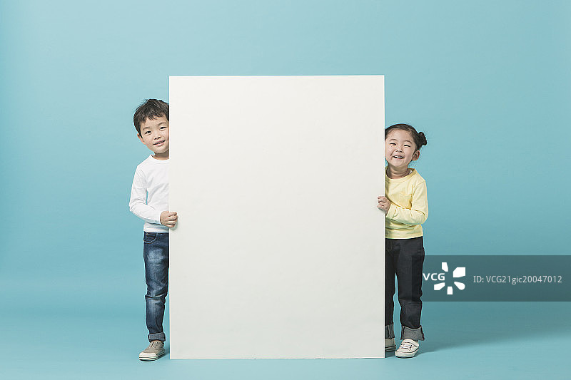 两个孩子站在白色横幅后面图片素材