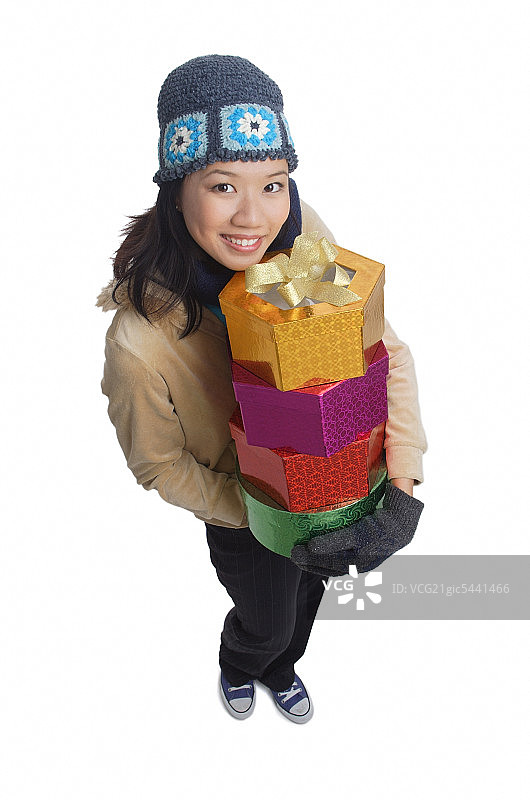 年轻女子拿着礼盒，对着镜头微笑图片素材
