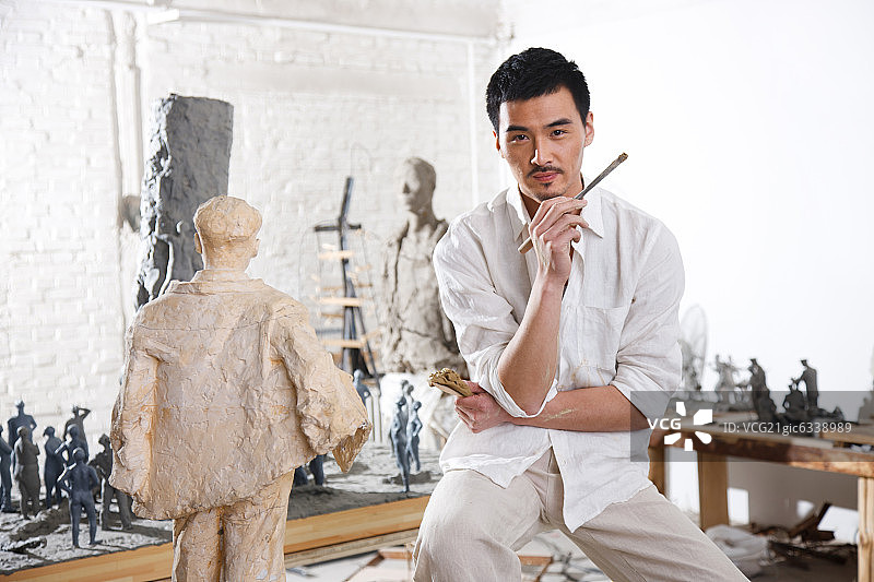 一个男雕塑家在工作室里创作图片素材