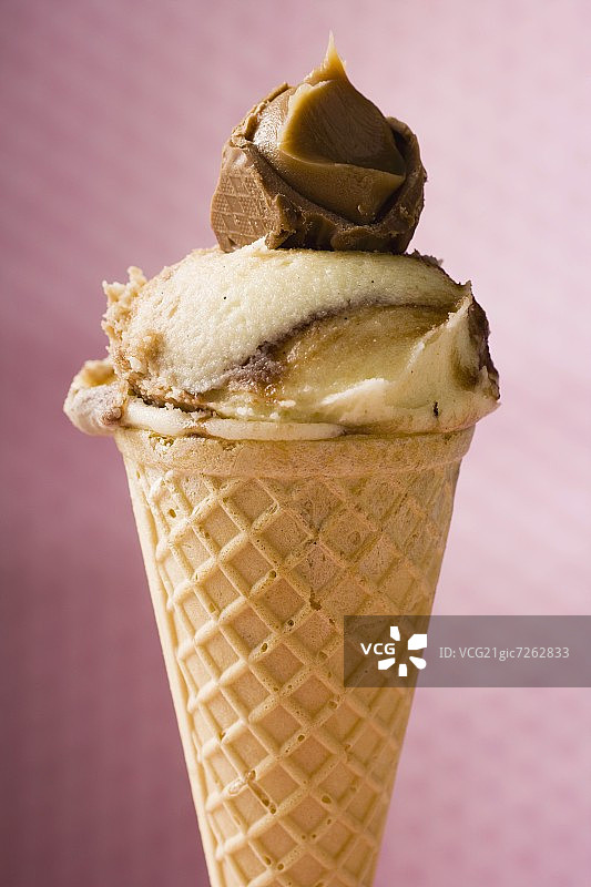 焦糖冰淇淋威化蛋筒在粉红色的背景图片素材