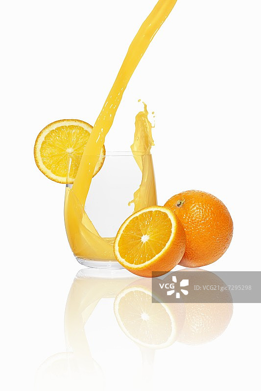 把橙汁倒进玻璃杯里图片素材