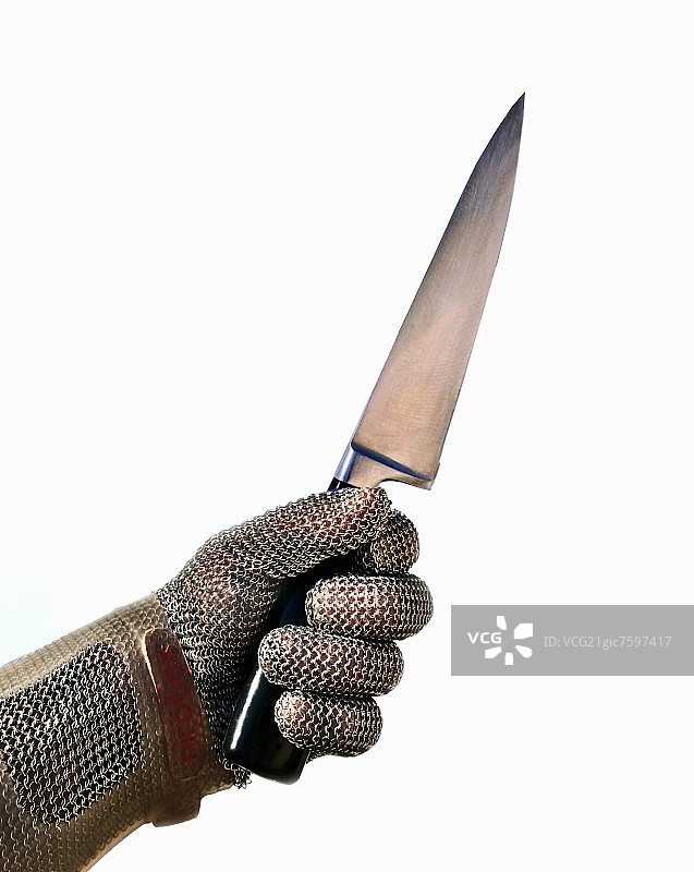 一只戴牡蛎手套的手拿着一把锋利的刀图片素材