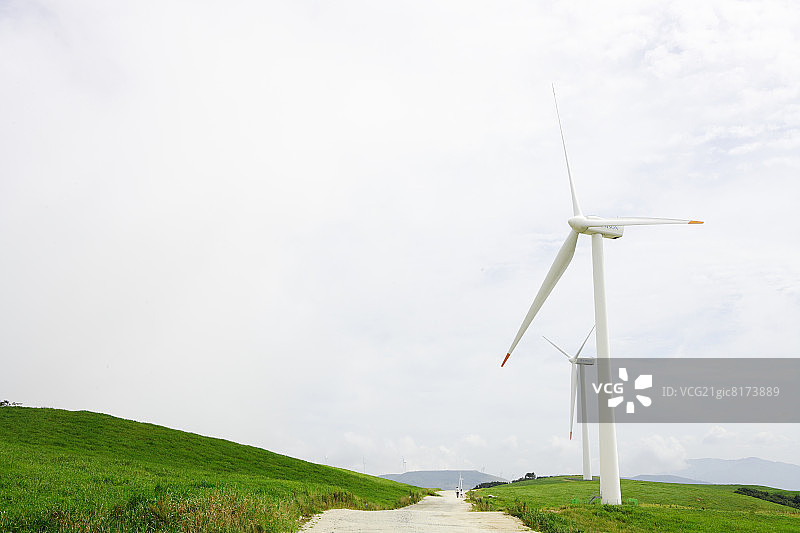风力涡轮机沿着乡村公路图片素材
