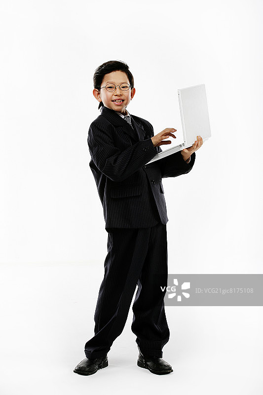男孩(12-13岁)使用笔记本电脑，微笑，肖像，特写图片素材
