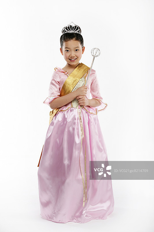 女孩(12-13)装扮成手持权杖的美丽女王，面带微笑，肖像图片素材