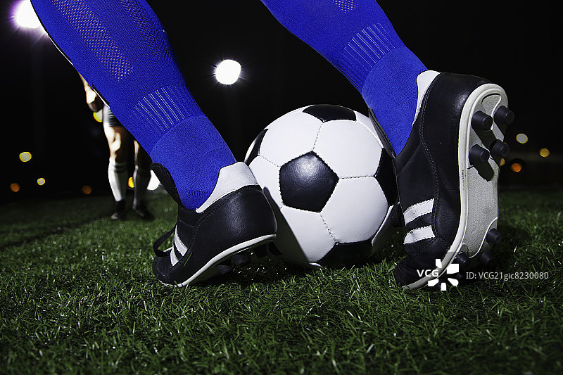 足球脚的特写，晚上在体育场图片素材