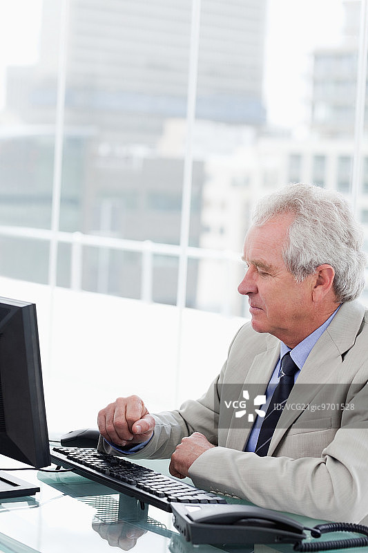 一位高级经理在办公室里用电脑工作的肖像图片素材