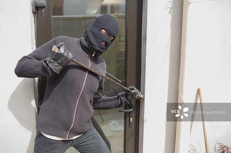 强盗用撬棍从后门进入房屋图片素材