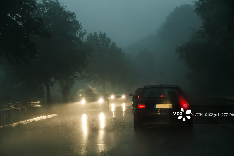 黄昏下暴雨时县道上的交通图片素材