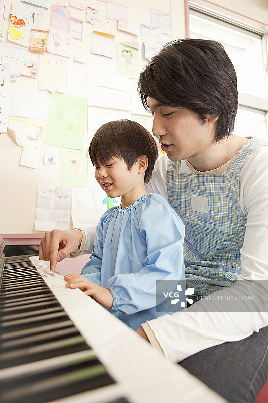 幼儿园老师和弹钢琴的男孩图片素材