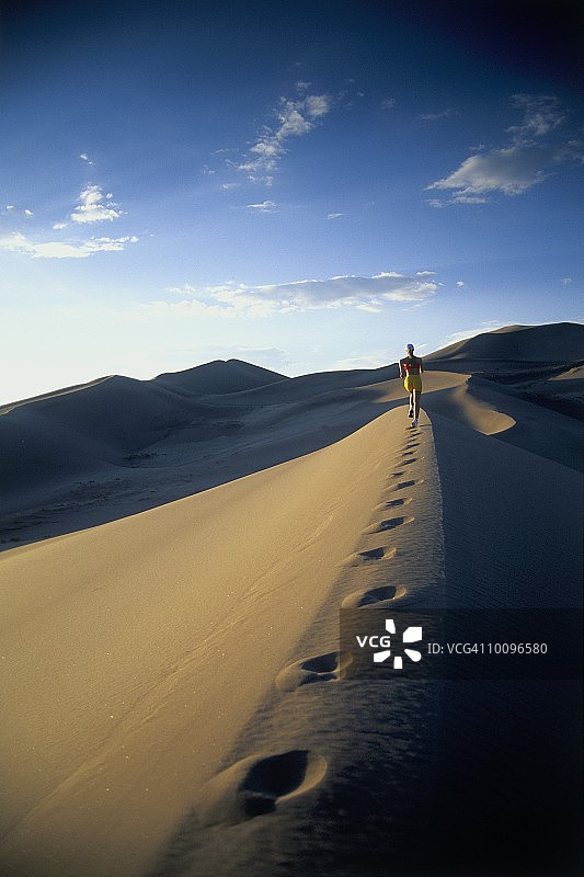 在科罗拉多州的大沙丘上跑步的女人图片素材