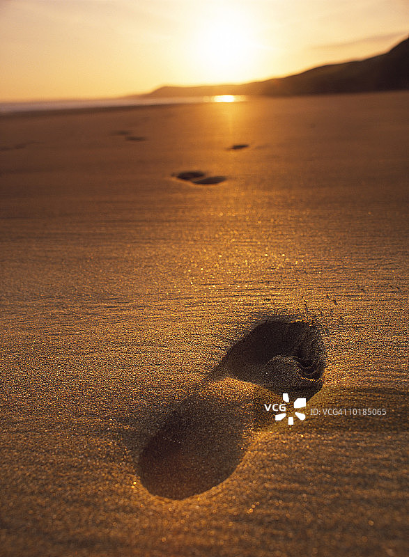 沙滩上的脚印，夕阳下的脚印图片素材