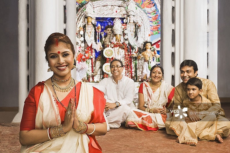 一个女人和他的家人在寺庙里祈祷图片素材
