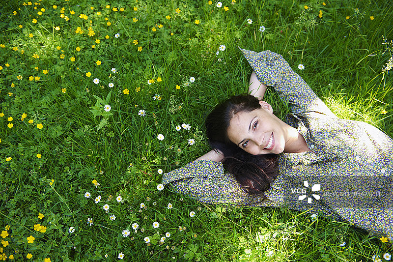 女人躺在花园里，微笑着图片素材
