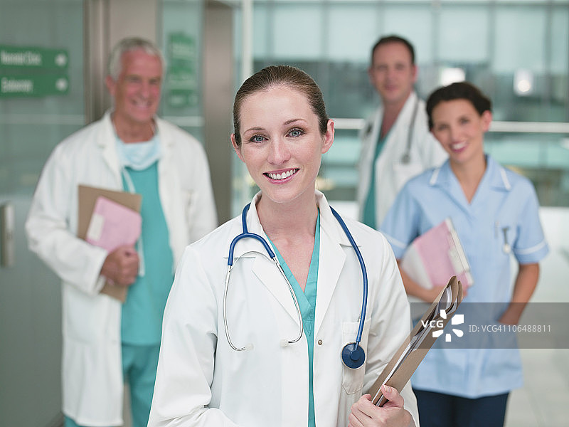 快乐的白人医生，男医生和护士在她身后图片素材