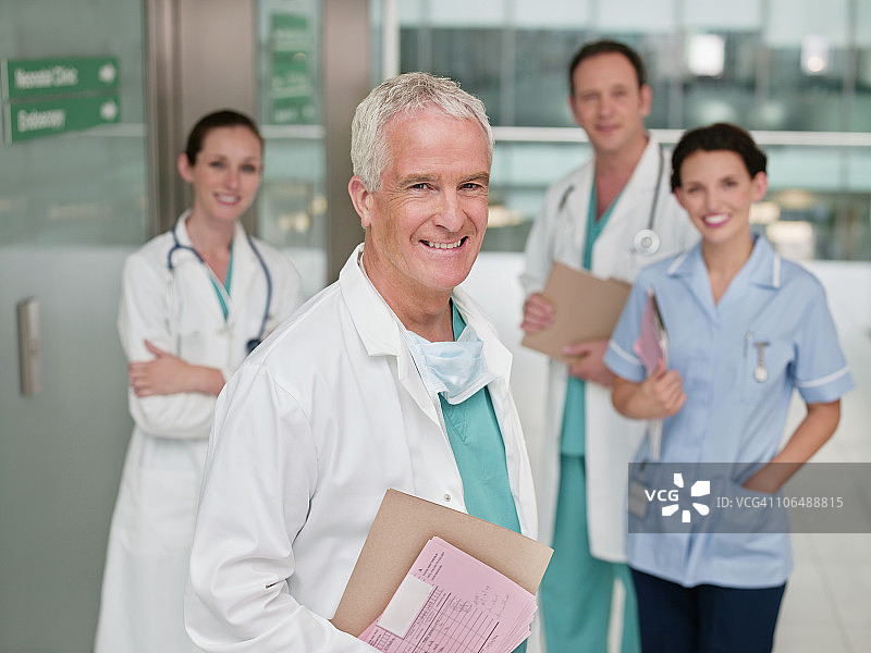 四名身穿白大褂的医生微笑着在医院里画像图片素材