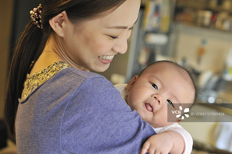 抱着婴儿的母亲，微笑图片素材